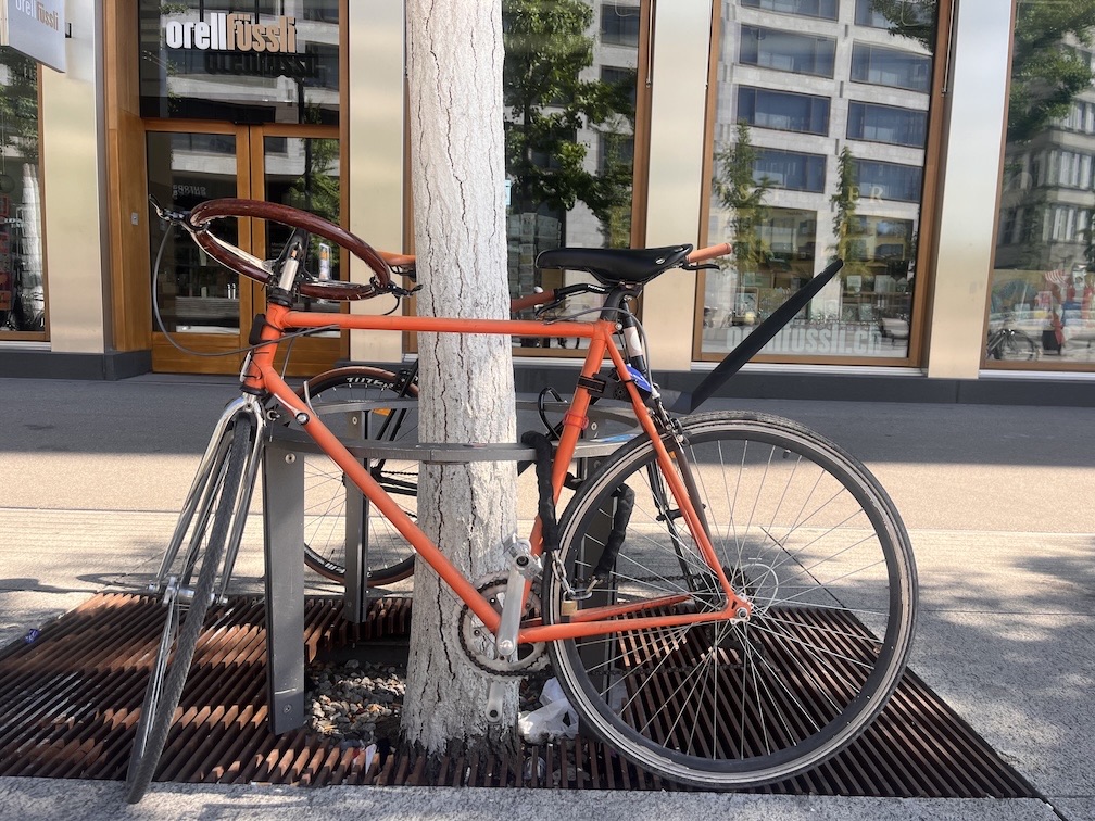 Orange KoolVelo prototype bicycle with a wooden sports-car steering wheel in Zurich